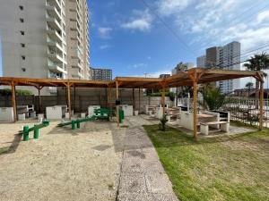 a picnic area with benches and a wooden pavilion at Departamento Amoblado 3 Habitaciones in Coquimbo