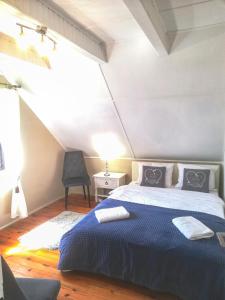 - une chambre avec un lit doté d'une couverture bleue et d'une chaise dans l'établissement Wałpusz Holiday Home, à Szczytno