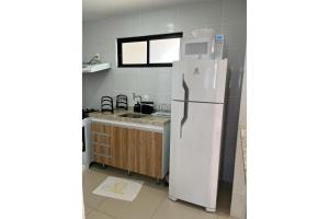 une cuisine avec un réfrigérateur et un micro-ondes dans l'établissement Lindo apartamento, ao lado do Shopping Partage Nova Betânia Ed WHB, à Mossoró