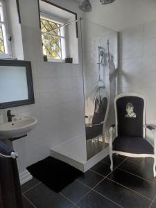 La salle de bains est pourvue d'une chaise et d'un lavabo. dans l'établissement Ma promesse, à Vals-les-Bains