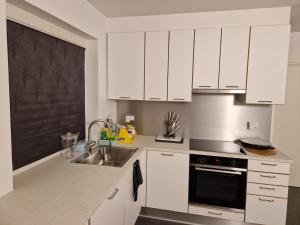 - une cuisine avec des placards blancs et un évier dans l'établissement Guest House Rens, à Bylderup-Bov