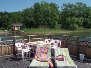 エーケレーにあるThree-Bedroom Holiday home in Skåの川沿いのデッキ(テーブル、椅子付)
