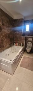 ein Bad mit einer Badewanne und einem WC in der Unterkunft Appartement à Bizerte in Bizerte