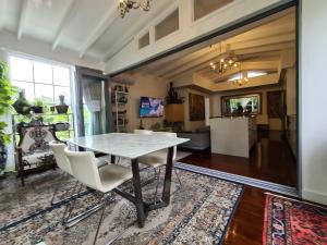 a dining room and living room with a table and chairs at Bamboo House, Close to the City & Airport & Train station and Brighton Le Sands Beach in Sydney