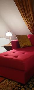 een rode bank in een woonkamer met een lamp bij Maisonette Elisabeth in Trier