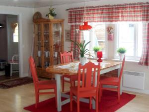a dining room with a table and red chairs at Three-Bedroom Holiday home in Skå in Ekerö