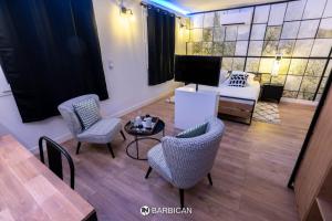 sala de estar con sillas, mesa y sofá en Barbican en Villars-les-Dombes