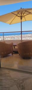 two chairs and an umbrella on a beach at Appartement à Bizerte in Bizerte
