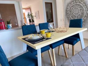 une table à manger avec des chaises bleues, une table et des chaises dans l'établissement Alta Mar Ocean Sky, à Carthagène des Indes