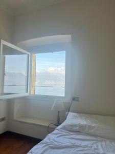 um quarto com uma janela com uma cama e um candeeiro em liberty lake house em Stresa