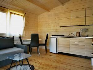 a kitchen and a living room with a couch and a table at Rio Park domki letniskowe Łukęcin in Łukęcin