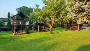 a park with a playground and a tree at PanOli Apartmanház Nyíregyháza in Nyíregyháza