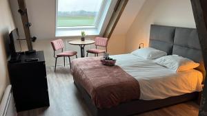 een slaapkamer met een bed en een tafel en stoelen bij Vakantieboerderij Huize Nuis in Noordbeemster