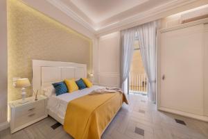 a bedroom with a bed with yellow and blue pillows at YourHome - Royal Blue Suite in Sorrento