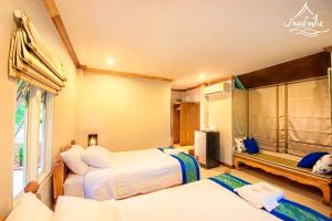 a bedroom with two beds and a shower at Baan Nam Pen Resort in Amphawa
