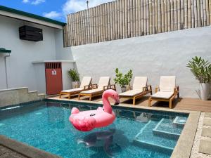 a pink inflatable swan in a swimming pool at Hotel Por Que No? in Uvita