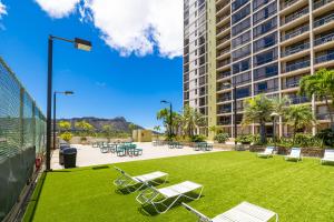 a park with chairs and tables and a building at Beautiful Mountain Views Condo, Parking is free! in Honolulu