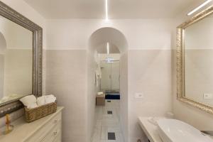 a white bathroom with a sink and a mirror at YourHome - Royal Blue Suite in Sorrento +14 photos