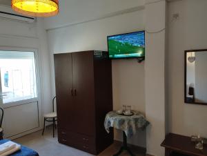 a room with a tv on a wall with a table at Hotel Kima in Kamariotissa