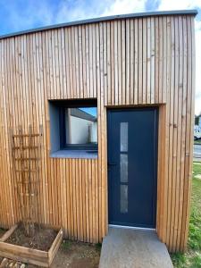 budynek z niebieskimi drzwiami i oknem w obiekcie L'Orée du Golf, studio 2 w mieście Mont-Saint-Aignan +1 zdjęcie