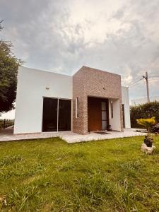 un grand bâtiment blanc avec une pelouse dans l'établissement Casa campestre Buenavista - La Mesa, à La Mesa