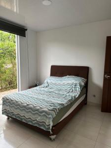 1 cama en un dormitorio con ventana grande en Casa campestre Buenavista - La Mesa en La Mesa