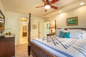 a bedroom with a bed with a ceiling fan at Mauna Lani Fairways 401 in Waikoloa