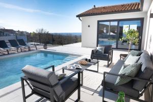 a patio with chairs and a swimming pool at Villa TonKa with jacuzzi sauna and private pool in Labin