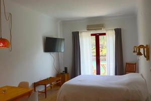 una stanza d'albergo con un letto e una finestra di Sunrise Apartmento Ribeira d'Ilhas Ericeira a Ericeira