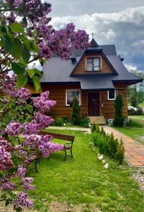 ブコビナ・タトシャンスカにあるDomek Pod Kogutkiem Na Dolinieの紫の花の家の前のベンチ