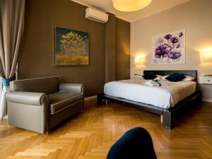 a hotel room with a bed and a chair at Attico 195 in Salerno