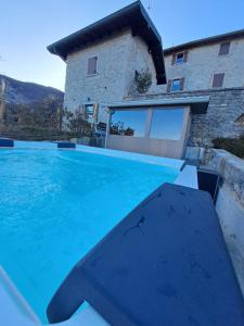 ein großer Pool vor einem Haus in der Unterkunft CA' BAETTI L'ANTICO BORGO in Roncola