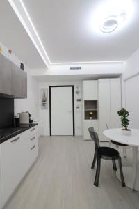a kitchen with white cabinets and a table and chairs at Ad un passo dal mare in Bari