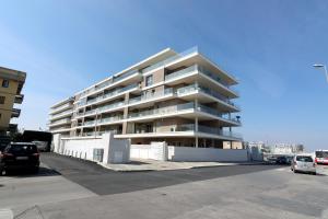 un edificio de apartamentos alto con coches estacionados en un estacionamiento en Ad un passo dal mare en Bari