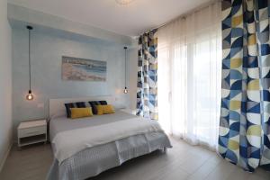 1 dormitorio con 1 cama con cortinas amarillas y azules en Ad un passo dal mare, en Bari