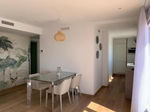 a dining room with a glass table and chairs at Atico Mosean in Vinarós +30 photos