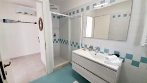 a white bathroom with a sink and a shower at Villa Barbara Fra i Pini in Lignano Sabbiadoro
