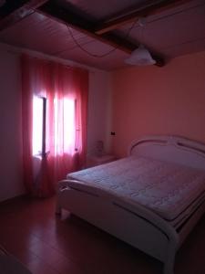 1 dormitorio con 1 cama y una ventana con cortinas rojas en Appartamento mare en Siderno Marina