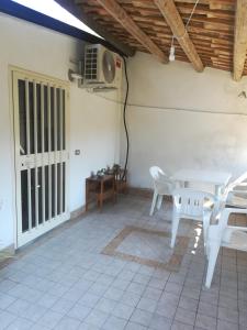 d'une terrasse avec une table et des chaises blanches ainsi qu'un ventilateur. dans l'établissement Appartamento mare, à Siderno Marina