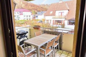 a table and chairs on a balcony with a grill at Ferienwohnung in zentraler Lage und Kurparknähe in Bad Lauterberg