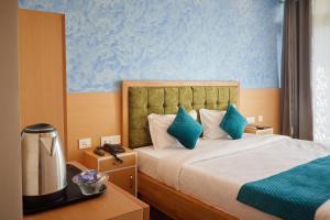 Habitación de hotel con cama con paredes azules en Rajaji Delight, Rajaji National Park, Rishikesh en Rishīkesh