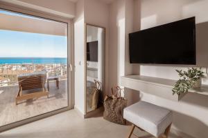 uma sala de estar com uma porta de vidro deslizante e vista para o oceano em Phoenix Apartments em Zakynthos Town