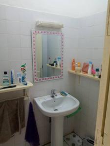 a bathroom with a sink and a mirror at La villa du cocotier in Sali Nianiaral