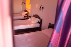a small room with two beds and a mirror at Pink Palace Beach Resort in Agios Gordios