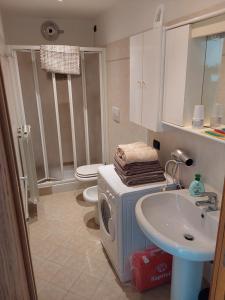 ein Badezimmer mit einem WC, einem Waschbecken und einer Waschmaschine in der Unterkunft La casa di Alyss in Bergamo