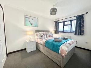 ein Schlafzimmer mit einem Bett, einer Lampe und einem Fenster in der Unterkunft 3 Bedroom house - Sandown in Sandown