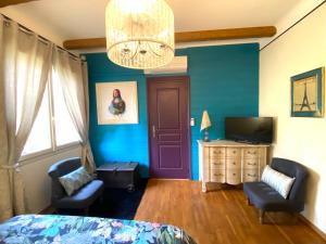 a bedroom with blue walls and a bed and a chandelier at Ô Clair de Lune Chambres d'hôtes climatisées à Sarlat - parking privé - piscine chauffée - espace bien-être Jacuzzi et massages in Sarlat-la-Canéda