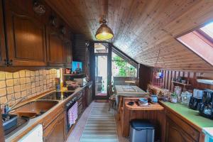 cocina con armarios de madera, fregadero y mesa en Haus im Hanfbachtal, 