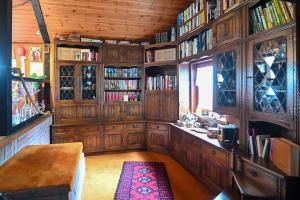 a library with wooden cabinets and a table and a window at Haus im Hanfbachtal 