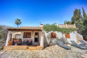 a house with two chairs and a patio at Chalet Tres Mares, Cala Millor in Son Servera